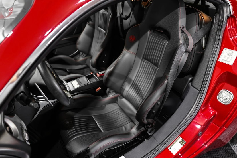 Close-up of a car's interior with gray seats and red exterior