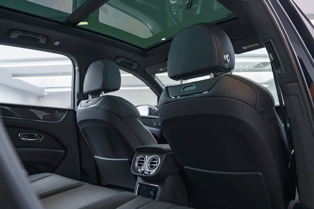 Interior of a luxury car with gray seats and sunroof.