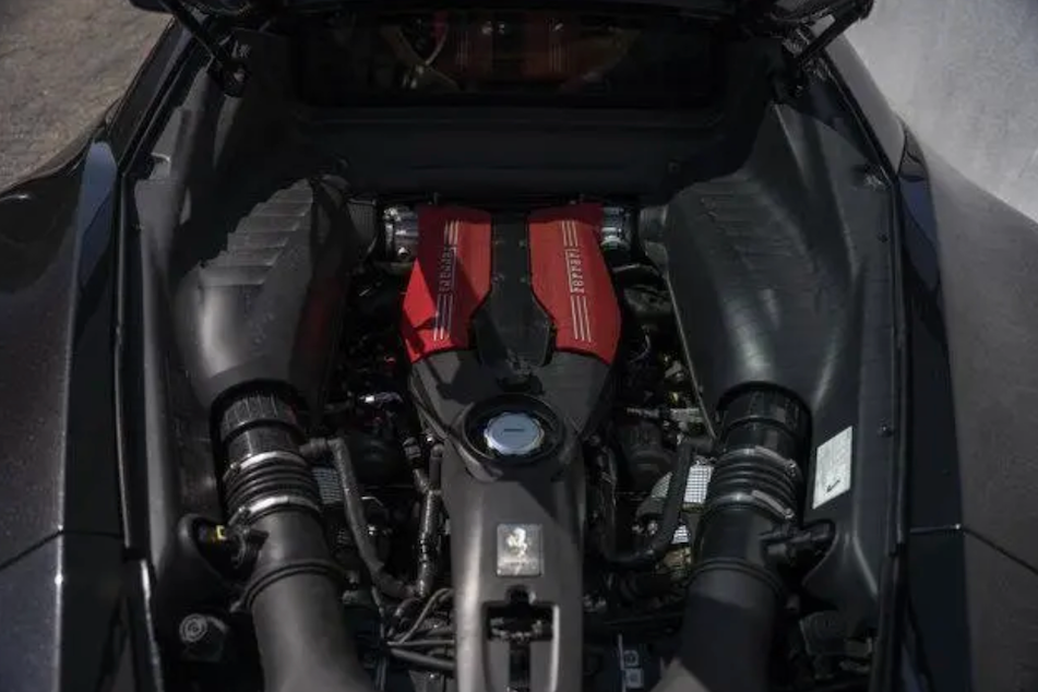 Engine bay of a vehicle with a prominent red valve cover