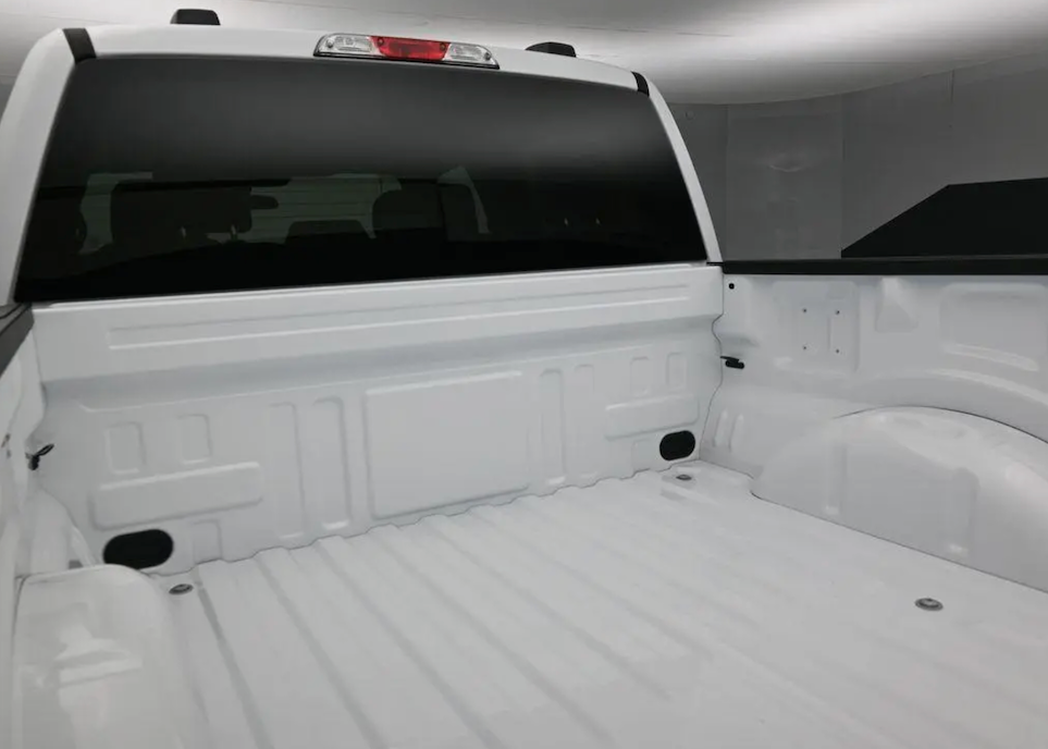 Empty white truck bed with a black tonneau cover
