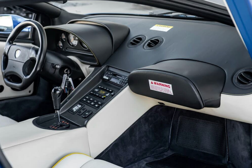 Car interior with dashboard, steering wheel, and passenger seat.