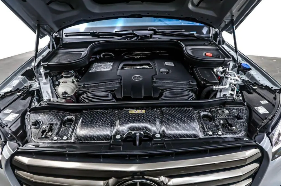 Car engine compartment with visible Mercedes-Benz logo