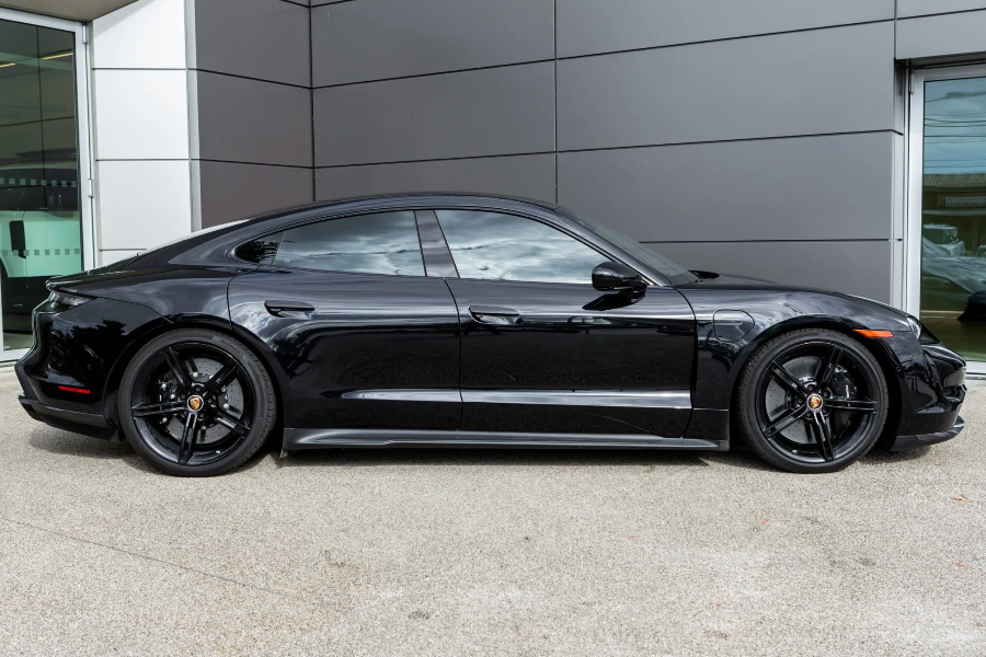 Black Porsche car parked in front of a modern building