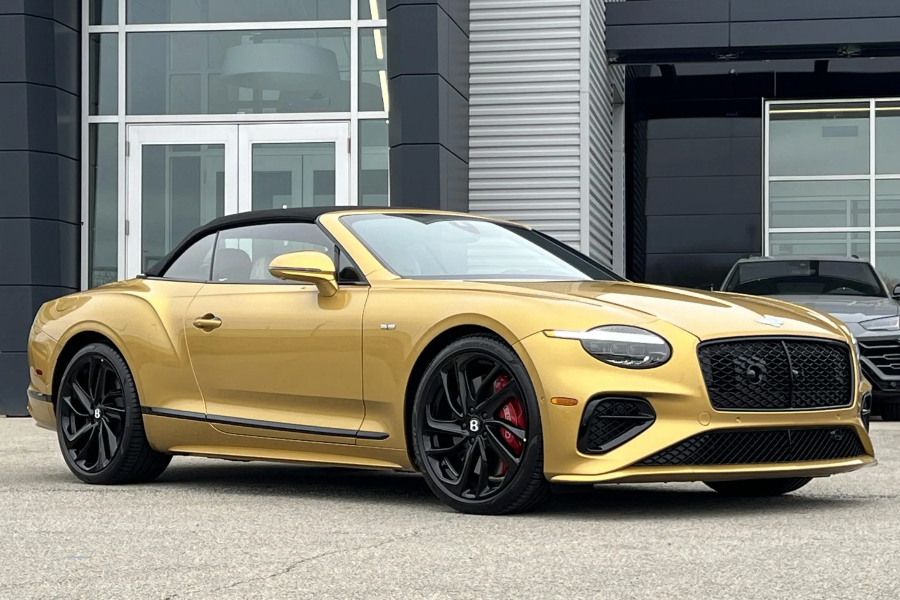 Gold convertible car parked in front of a modern building