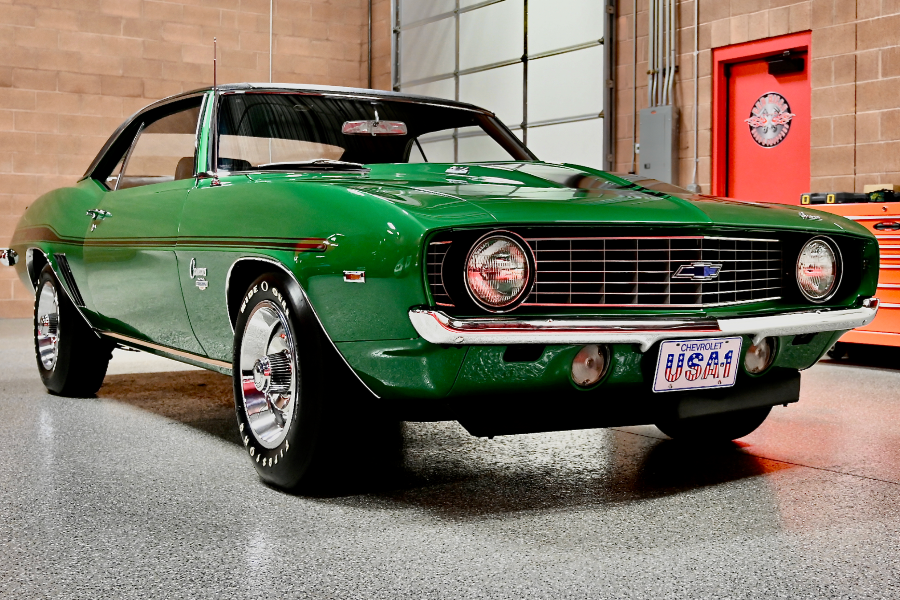Green Chevrolet Camaro muscle car in a garage