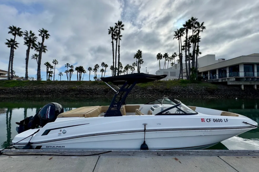 White boat on a dock with palm trees and buildings in the background