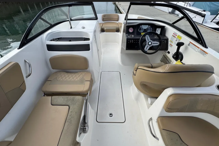 Interior of a boat with beige seats and white dashboard