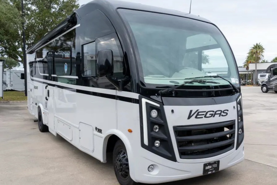 White bus with 'Vegas' branding on a concrete surface