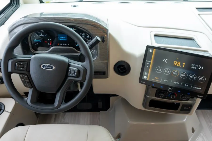 Car interior with steering wheel, dashboard, and infotainment system.