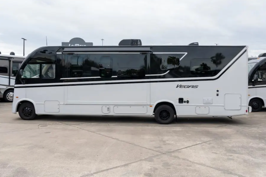 White bus with 'Vegas' branding on a concrete surface