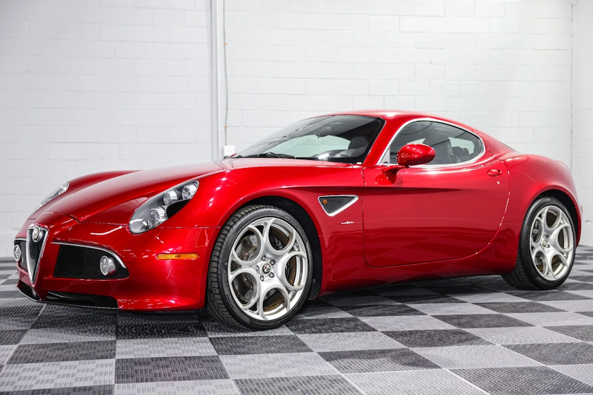 Red sports car on a checkered floor with a white wall background