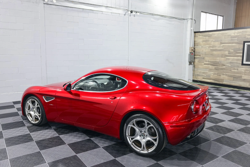 Red sports car in a garage with checkered floor
