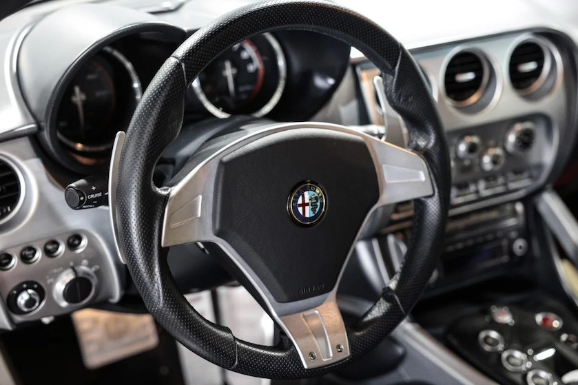 Steering wheel with Alfa Romeo logo in a car interior