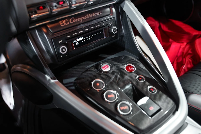 Car interior with a focus on the gear shift and control panel.