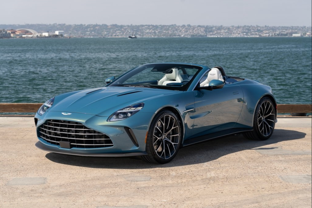 Luxury convertible car by a waterfront with a clear sky
