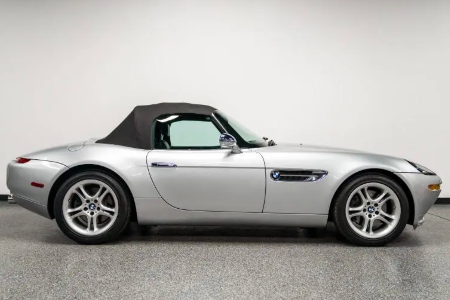 Silver convertible car on a gray floor with a white background