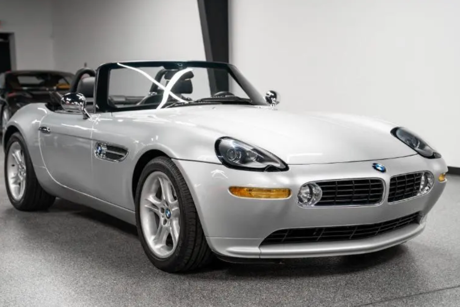Silver BMW Z8 convertible on a gray floor with a white wall background