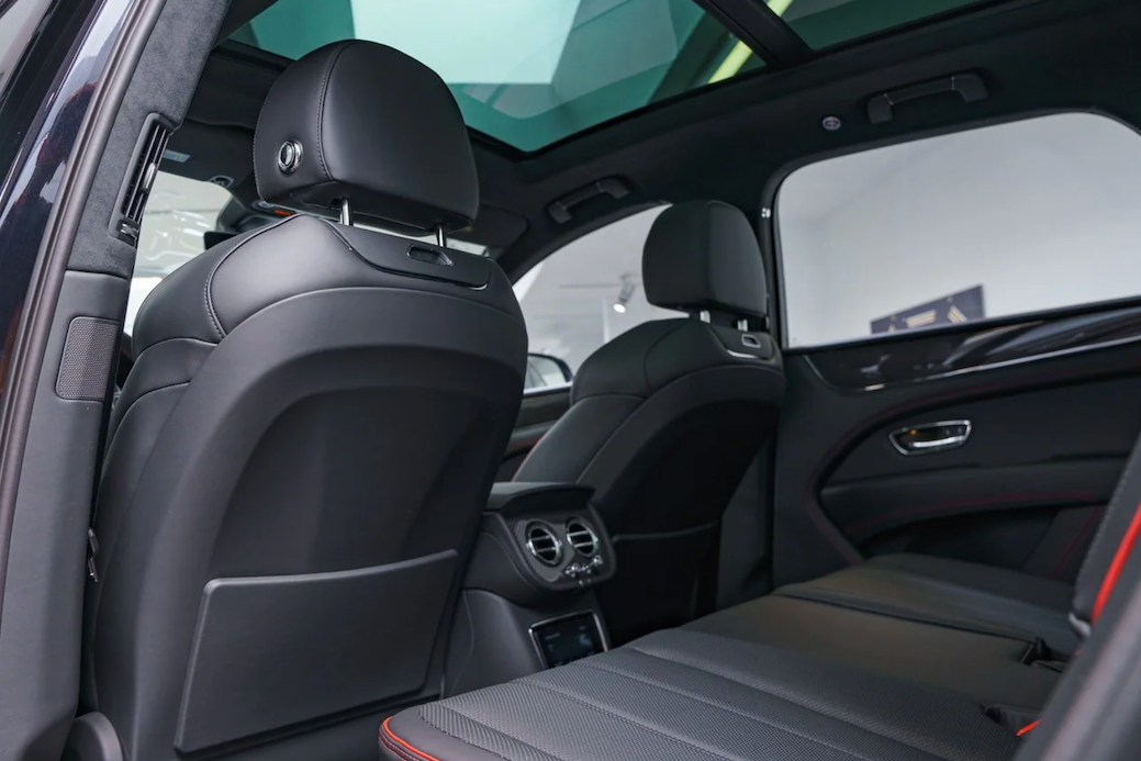 Luxury car interior with black leather seats and modern design elements.