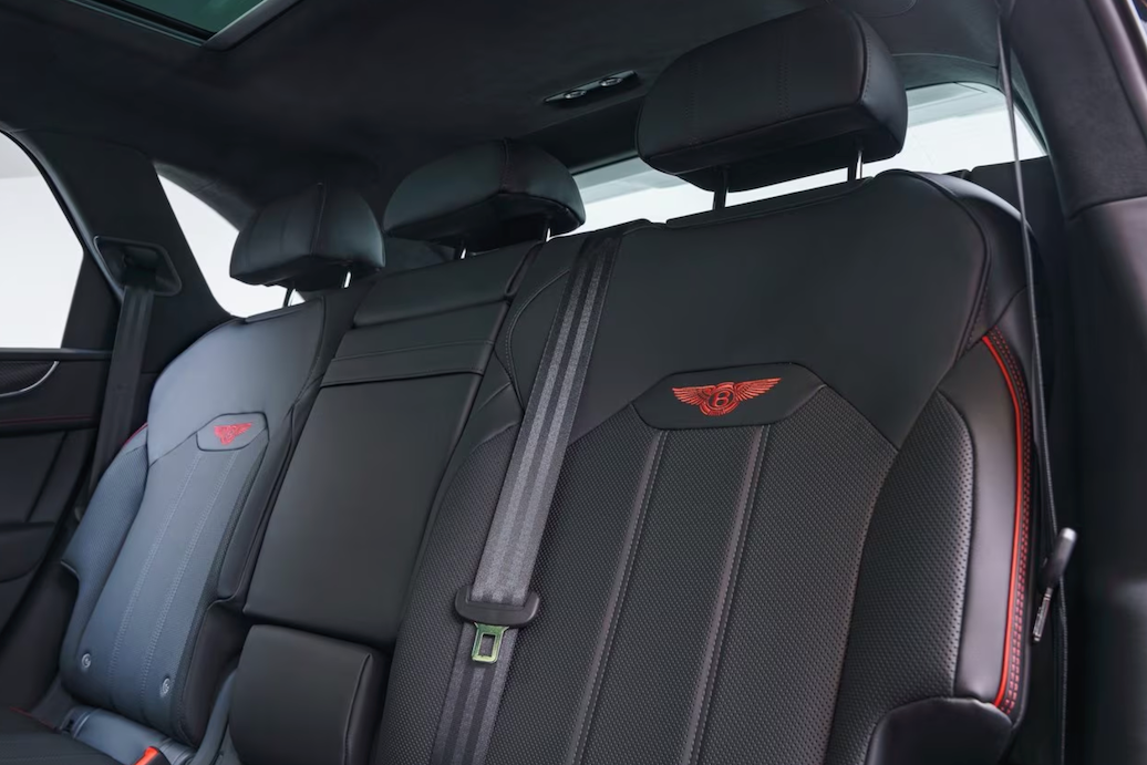 Car interior with black leather seats featuring a logo on the headrest.