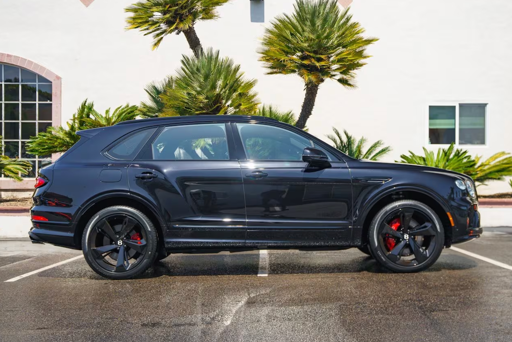 Black SUV parked in a parking lot with palm trees in the background