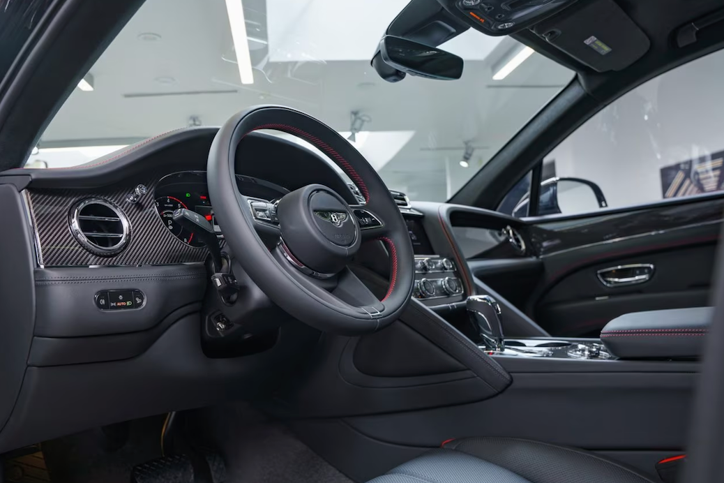 Luxury car interior with steering wheel and dashboard in a showroom setting