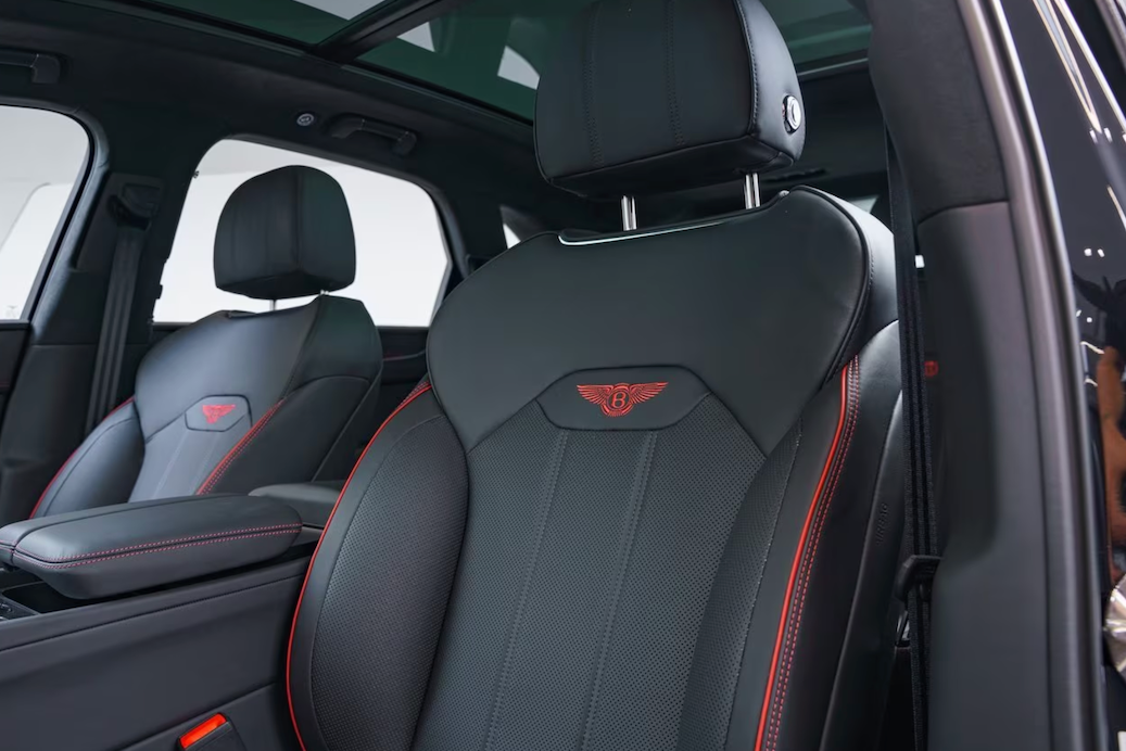 Close-up of car interior with black leather seats featuring a logo.