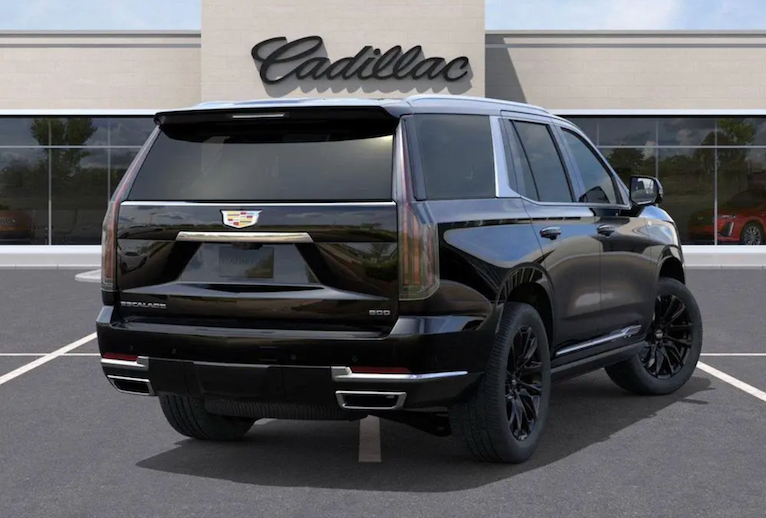 Black Cadillac SUV parked in front of a Cadillac dealership