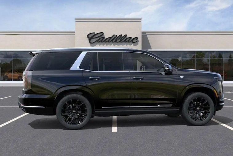 Black Cadillac SUV parked in front of a Cadillac dealership