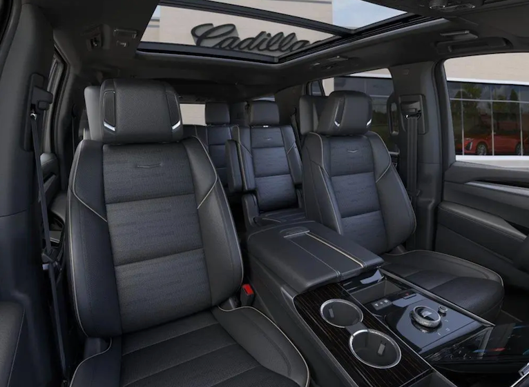 Cadillac SUV interior with black leather seats and panoramic roof.