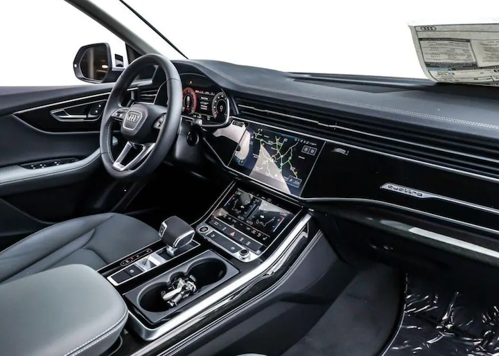Car interior with dashboard, steering wheel, and infotainment system.