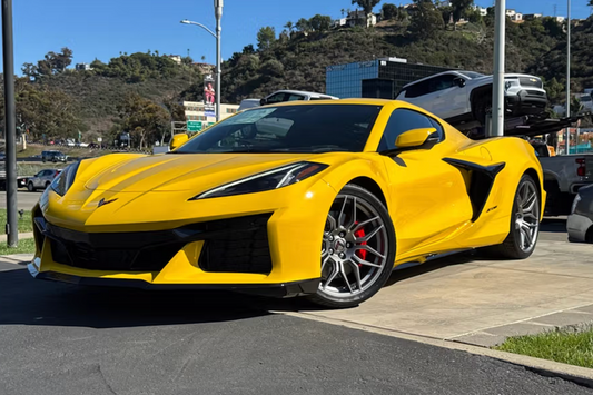 Yellow sports car parked on a street with a scenic background