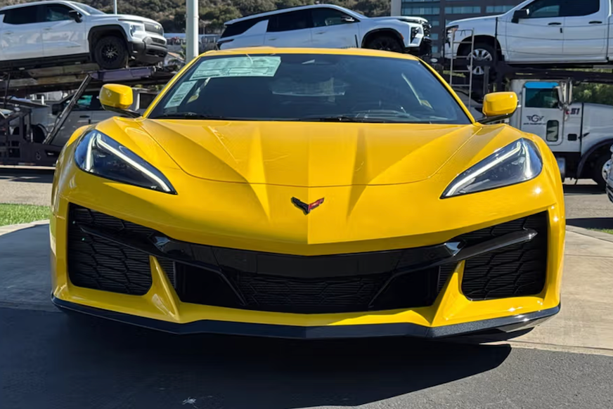 Yellow sports car with a visible Chevrolet logo on a paved surface.