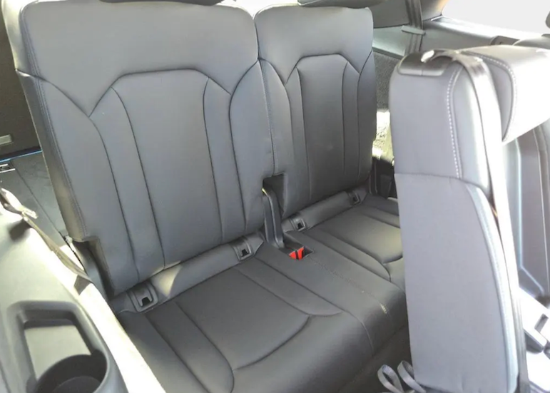 Gray car interior with two seats and a visible seat belt.