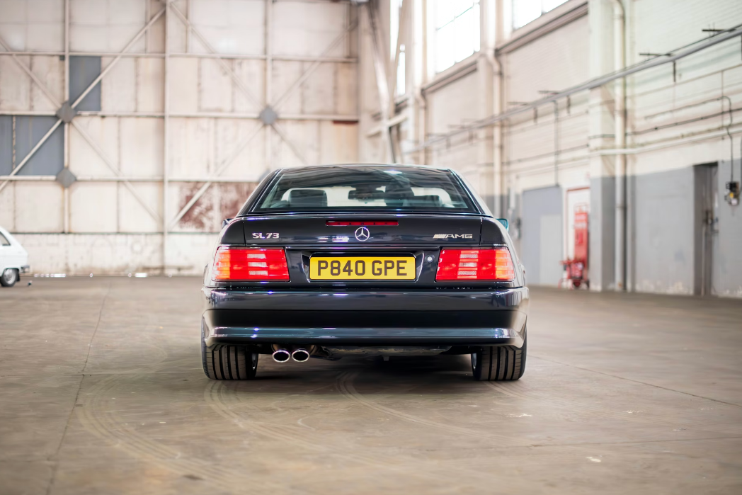 Mercedes-Benz car with a visible license plate in an industrial setting