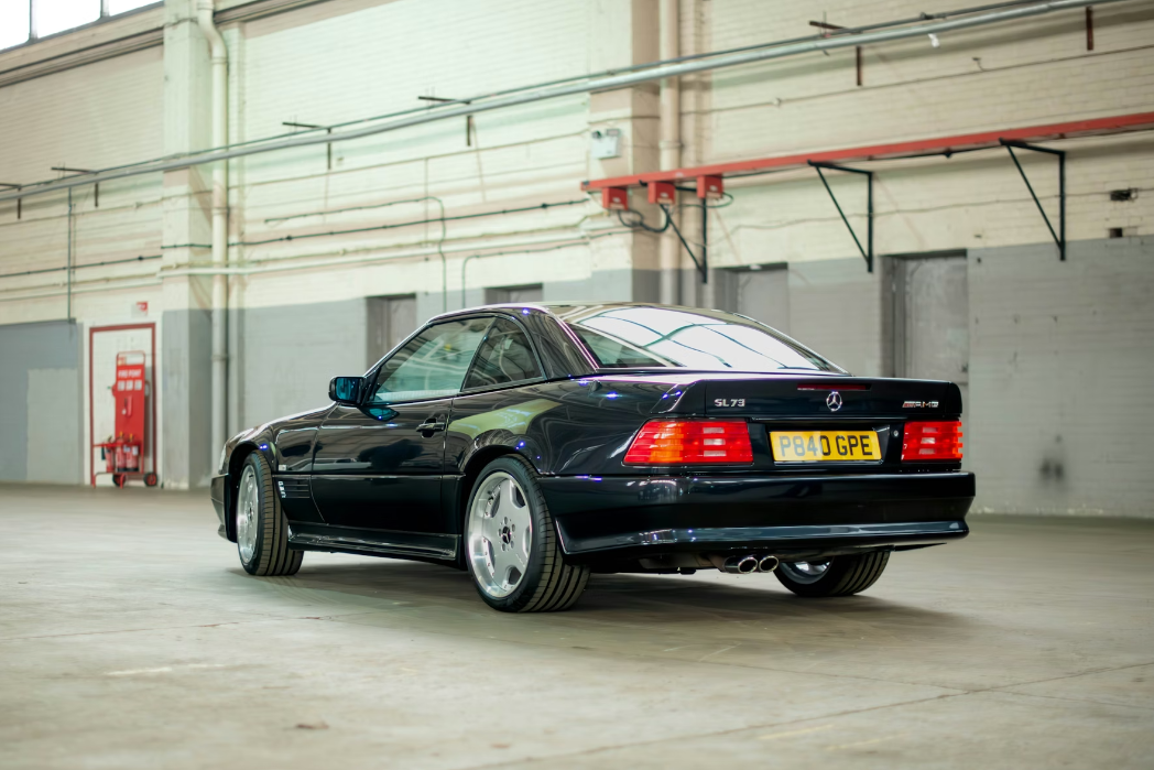 Black Mercedes-Benz car parked inside a warehouse.