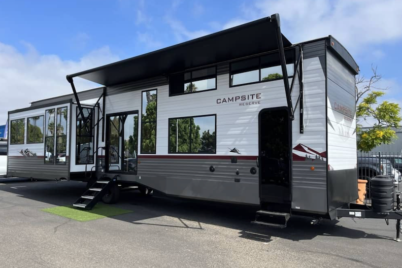 Modern RV with 'Campsite Reserve' branding on a clear day.