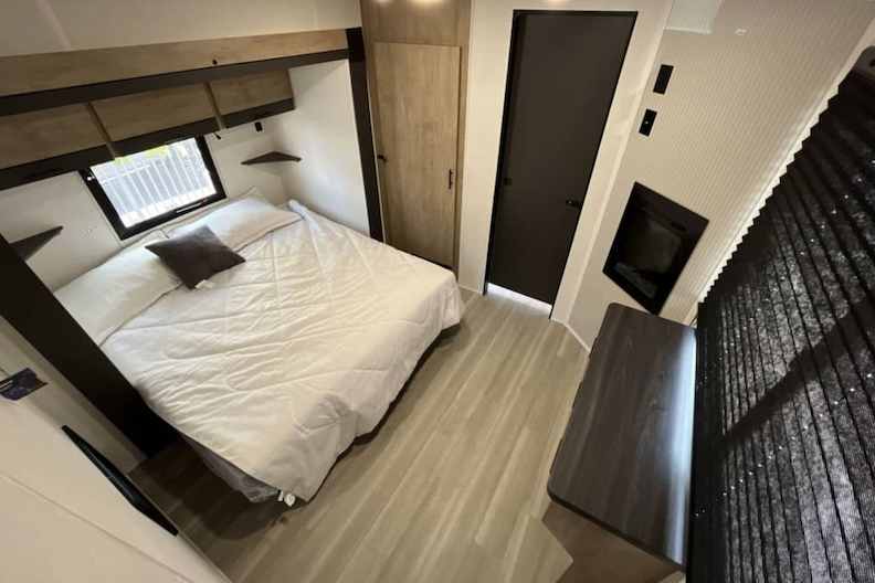 Modern bedroom interior with a bed, wardrobe, and desk.