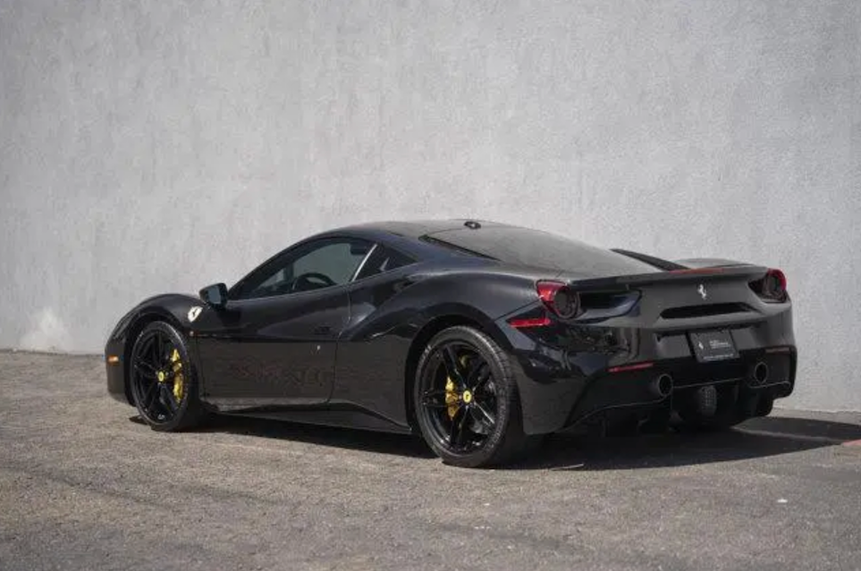 Black sports car parked on a gray surface with a gray background