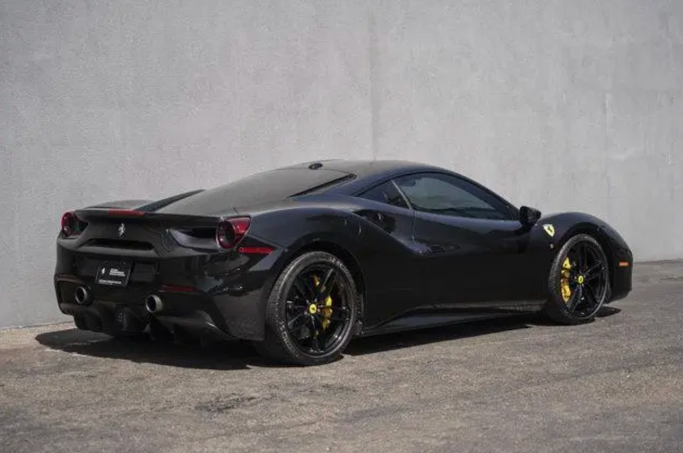 Black Ferrari sports car on a gray background