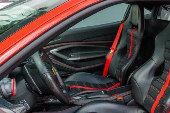 Close-up of a car's interior with black and red seats and dashboard.