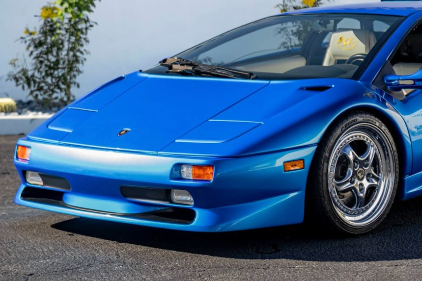 Blue sports car on a road with a clear sky background