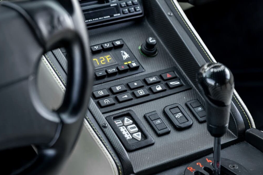 Close-up of a car's interior dashboard with controls and gear shift.