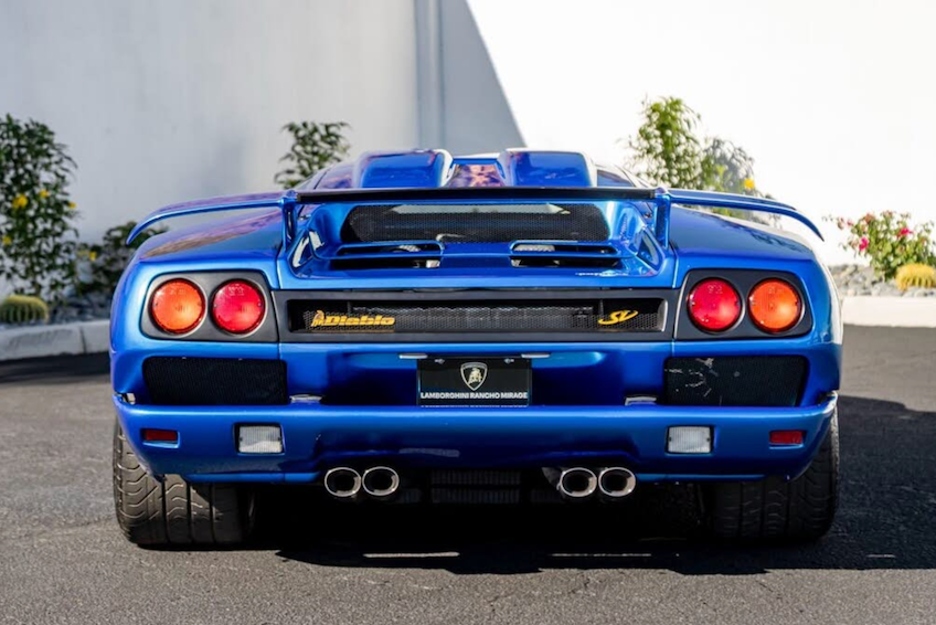 Blue Lamborghini sports car with visible branding on a road.