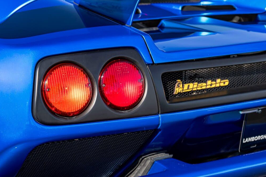 Close-up of a blue Lamborghini Diablo with red taillights and 'Diablo' branding.