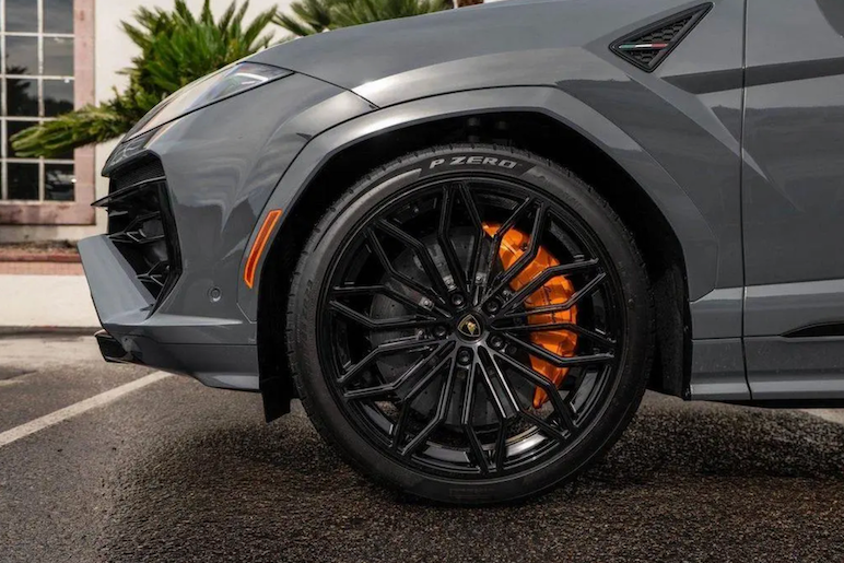 Gray SUV with black rims and orange accents on a street