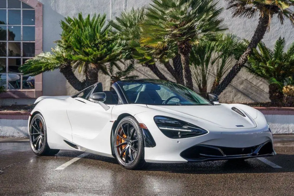 White sports car parked in a lot with palm trees in the background
