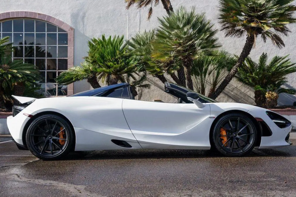 White sports car parked on a street with palm trees in the background