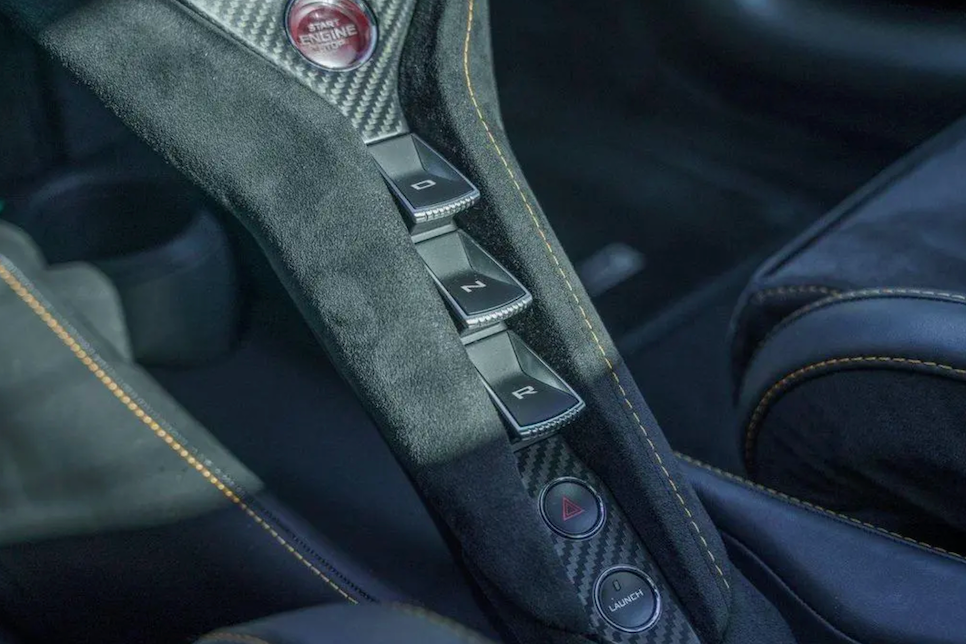 Close-up of a car seat control panel with buttons and a brand logo.