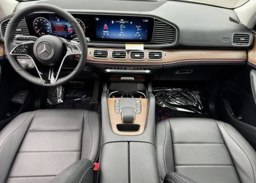Car interior with steering wheel, dashboard, and center console.