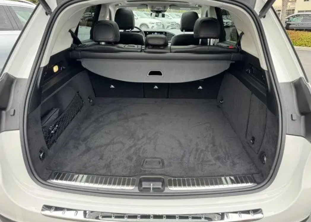 Open car trunk with gray interior and visible floor, parked outdoors.